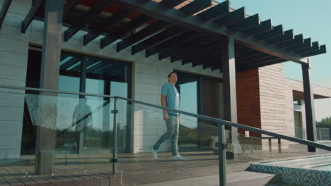 Happy-man-stretching-on-luxury-house-porch.-Leisure-morning-concept