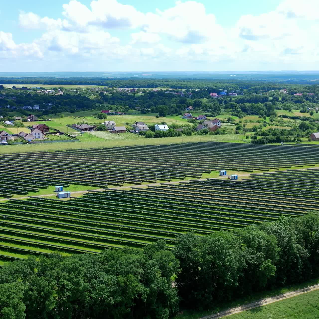 Solar farm in the countryside. Large solar power station with blue sunny batteries on field. Alternative source of sustainable energy. Aerial view