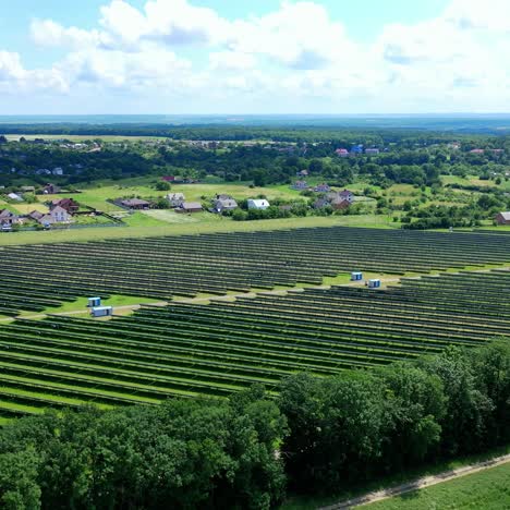solar farm in the countryside. large solar power station with blue sunny batteries on field. alternative source of sustainable energy. aerial view