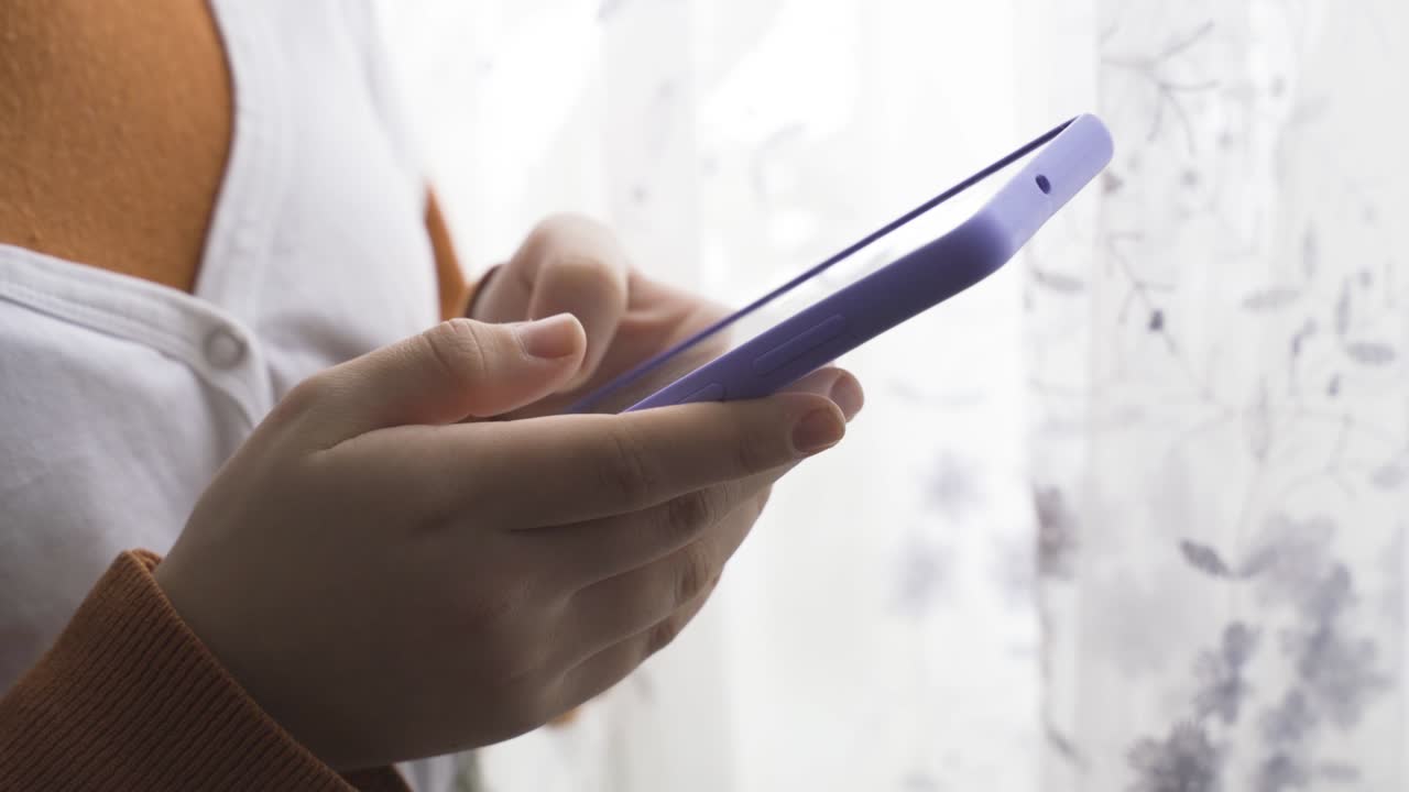 las manos de un adolescente escribiendo un mensaje en el teléfono