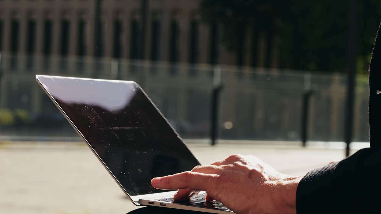 Asian businessman using laptop computer in the park, man working outdoor near modern office. Park street airport terminal