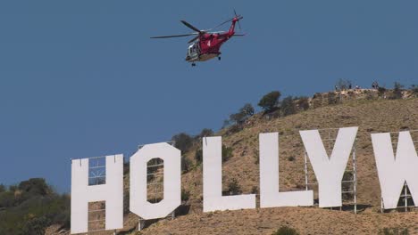 helicopter flies above the hollywood sign