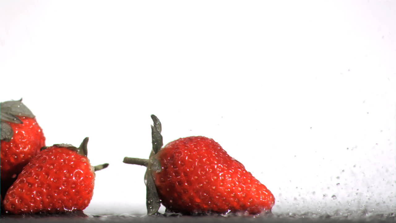 Strawberries in super slow motion receiving water