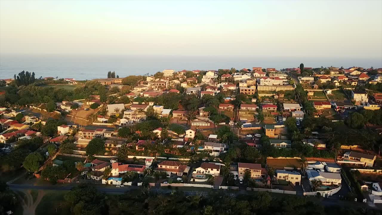 Drone che sorvola case residenziali colorate con una leggera vista mare in lontananza sul Bluff a Durban, Sudafrica