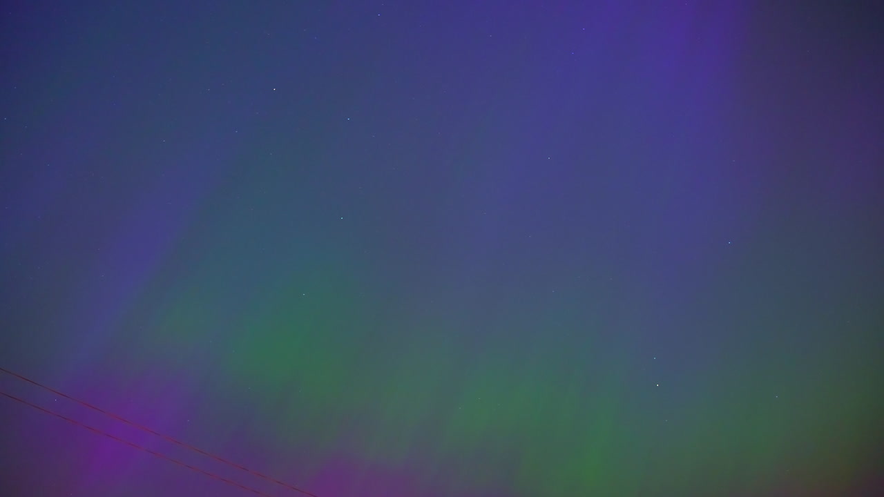 vibrantes colores púrpura y verde de la aurora boreal en el cielo nocturno, vista en lapso de tiempo