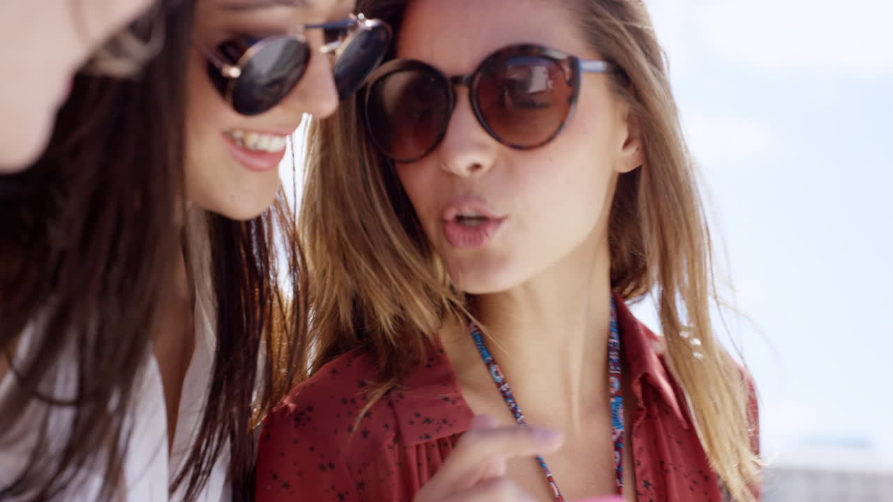 ⁇ 드폰을 사용하는 십대 소녀들이 소셜 미디어에서 여름 휴가 사진을 공유합니다.