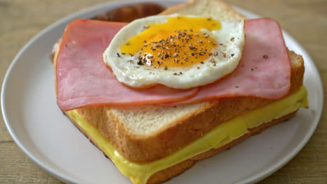 homemade-bread-toasted-cheese-topped-ham-and-fried-egg-with-pork-sausage-for-breakfast