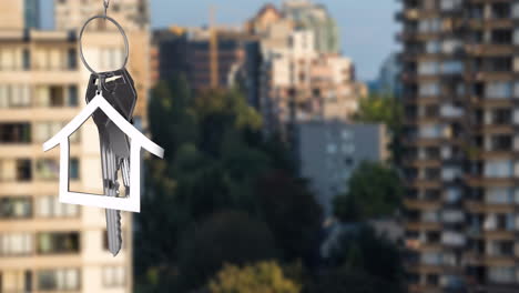 animation of silver house key and jey fob over cityscape