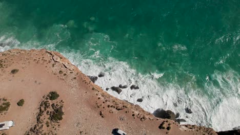 Vista-De-Drones-De-Altos-Acantilados-Con-Olas-Rompiendo-Contra-Las-Rocas-De-Abajo