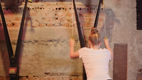 Side-View-Of-Young-Woman-Exercising-On-Cable-Machine-At-Fitness-Club-2