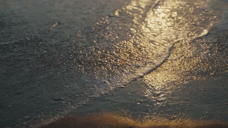 Wasser,-Das-Nach-Einer-Großen-Welle-über-Einem-Sandstrand-In-Mexiko-Zurückgeht,-Während-Das-Licht-Der-Untergehenden-Sonne-Im-Wasser-Funkelt