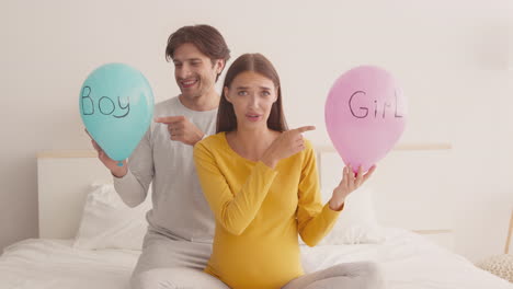 excited pregnant couple at gender reveal party