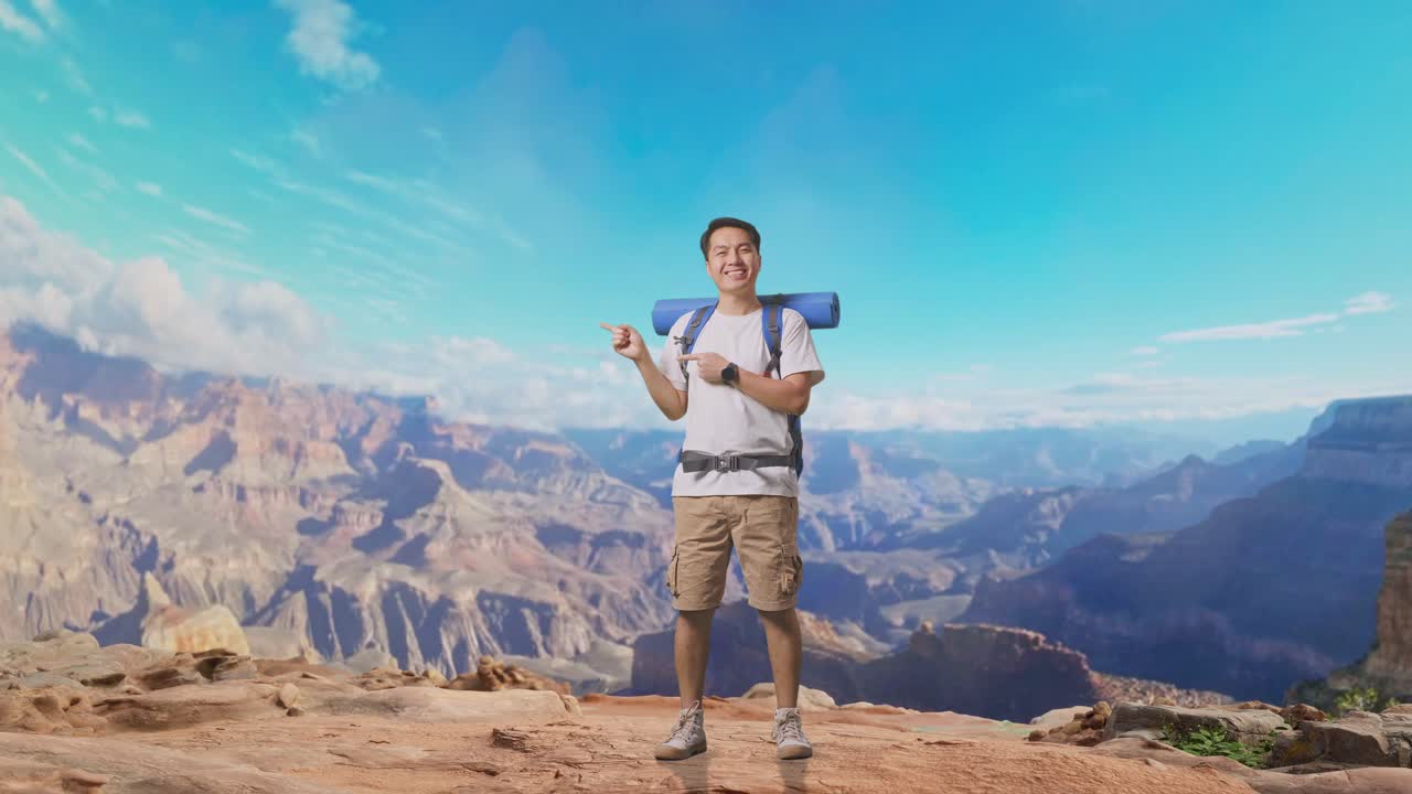 Full Body Of Asian Male Hiker With Mountaineering Backpack Smiling And Pointing To Side While Traveling At The Top Of Mountain