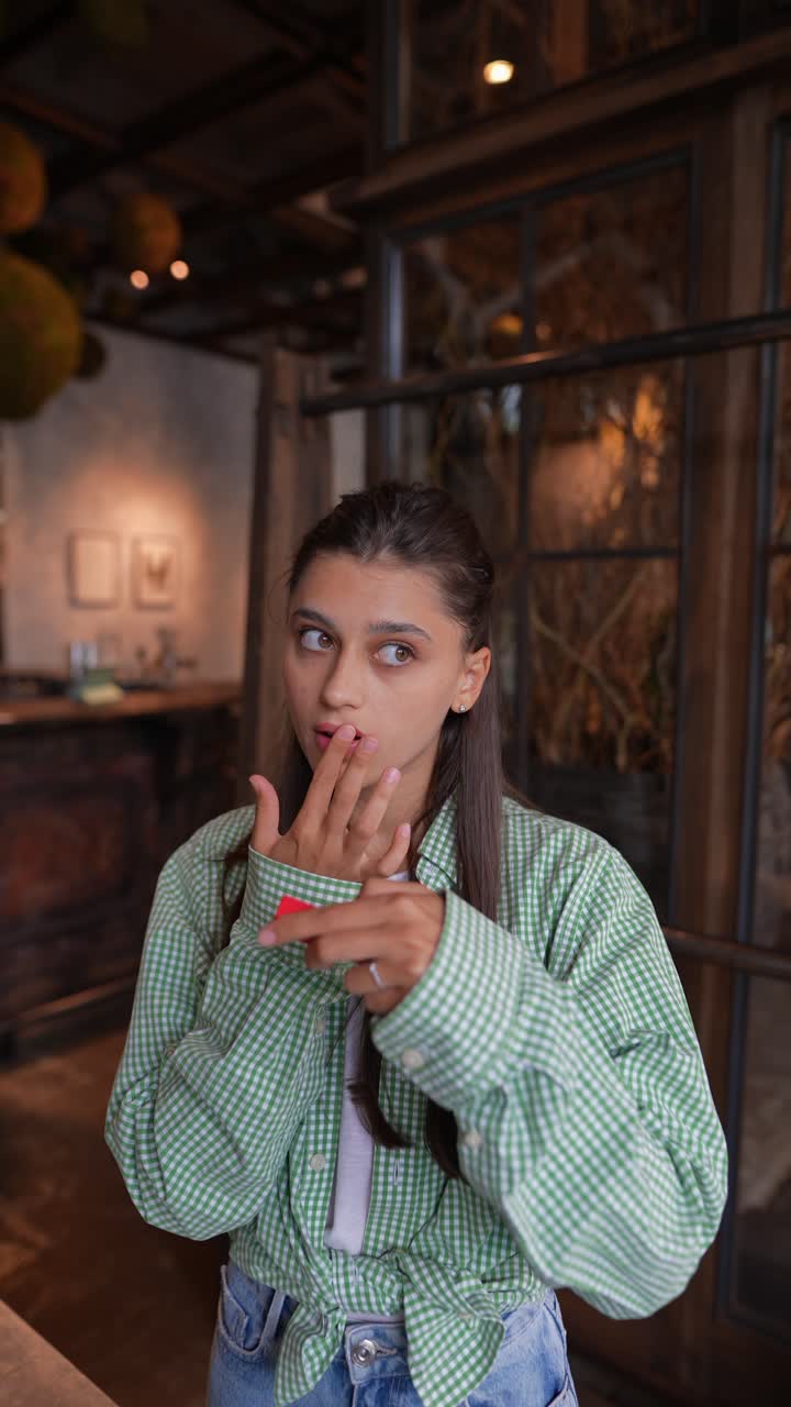Woman Applying Lipstick in a Cafe