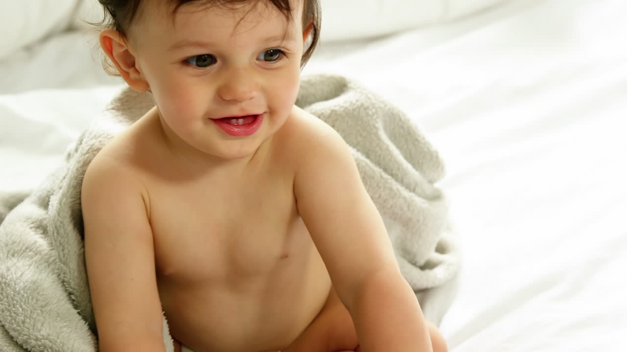 un bebé está sentado en una cama