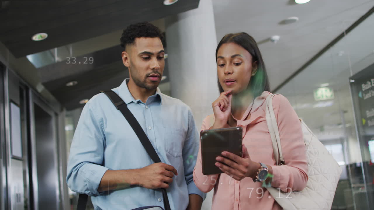 Animation of icons and changing numbers over diverse coworkers discussing reports on digital tablet