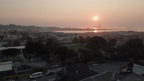 drone pushes into golden sunrise over san francisco's bayview neighborhood with light fog