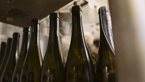 botellas de vino vacías en proceso de embotellado a la espera de llenarse de vino