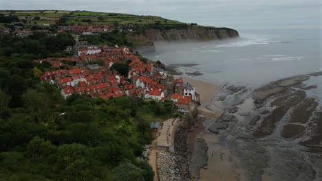 Establishing-Aerial-Drone-Shot-Around-Robin-Hood's-Bay-Coastal-Village-on-Misty-Morning-at-Low-Tide