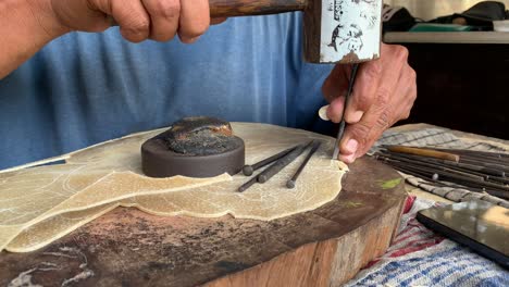 indonesian elderly man making carving hand made wayang shadow puppet