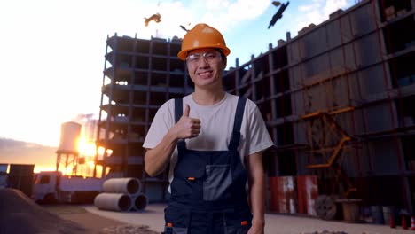 trabajador asiático mostrando el pulgar hacia arriba en el sitio de construcción