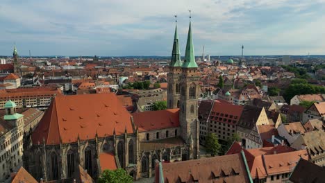 4k aerial drone video of the copper-clad twin spiers on the beautiful st. sebald church in downtown nurnberg, germany