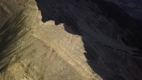 harsh light and dark contrast from morning golden hour light on top of mt nebo salt lake city utah - aerial pan