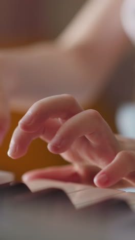 Girl with spinal injury plays piano at home. Skillful kid performs musical composition with steady flow between notes closeup on blurred background