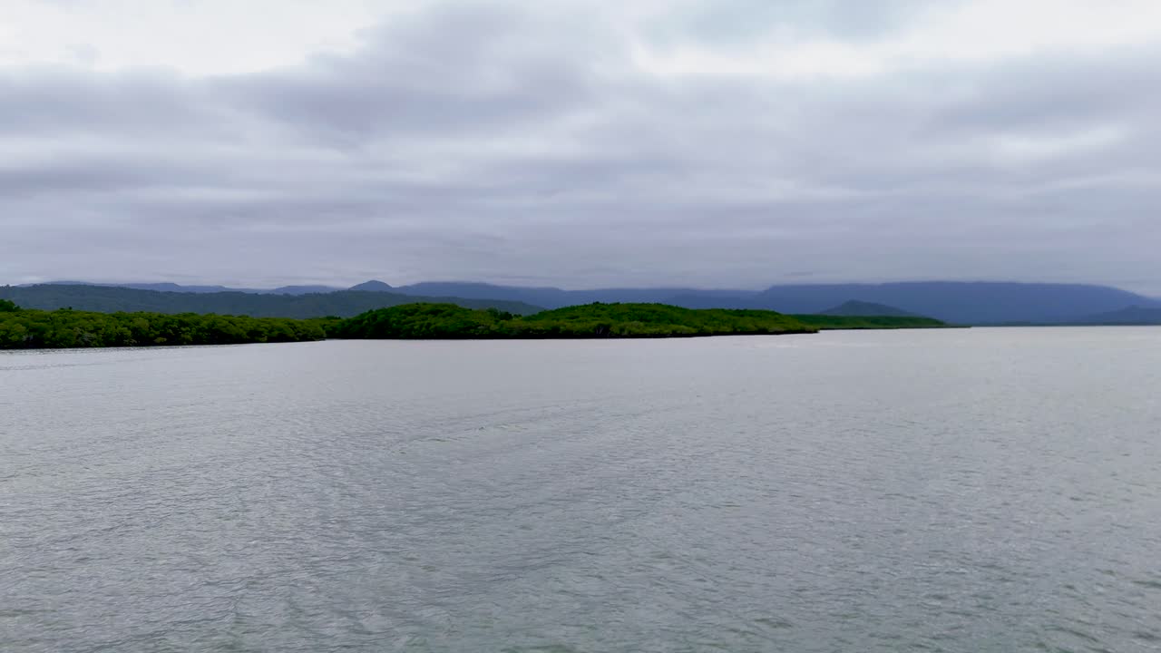 Drone footage captures the serene mangroves and coastline of Port Douglas, Australia, under overcast skies with smooth camera movement