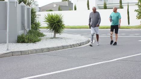 walking together, two men exercising outdoors, one with prosthetic leg