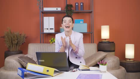 home office worker young woman looking at camera clapping and getting excited.