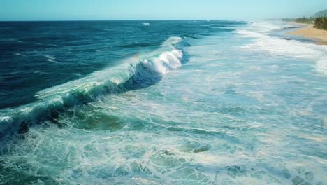 drone shot of the north shore coast of oahu showing huge waves crashing