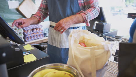 Primer-Plano-De-Una-Clienta-Pagando-Por-Productos-En-Una-Tienda-Agrícola-Utilizando-Una-Tarjeta-Sin-Contacto