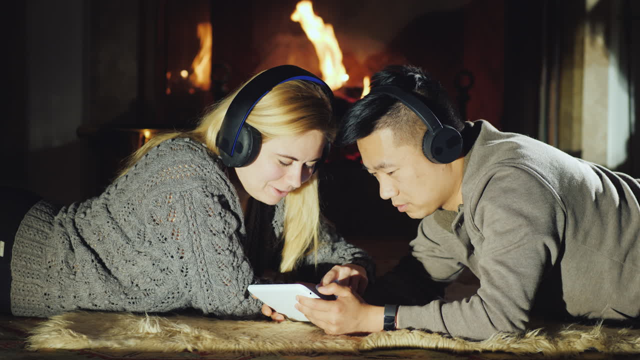 молодая пара делит планшет у камина 02