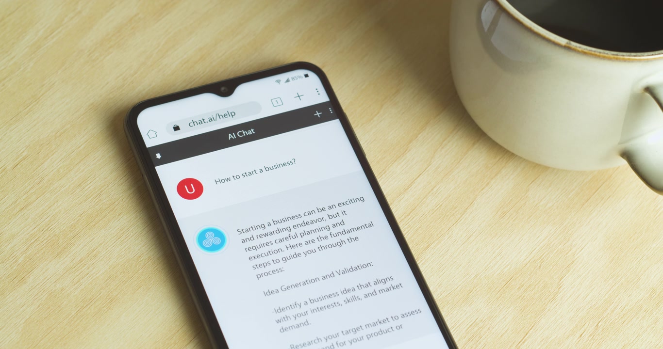 Intelligenza Artificiale - App chatbot AI su smartphone - Interfaccia telefono e app royalty-free - Primo piano medio, caffè - "Come avviare un'attività?"