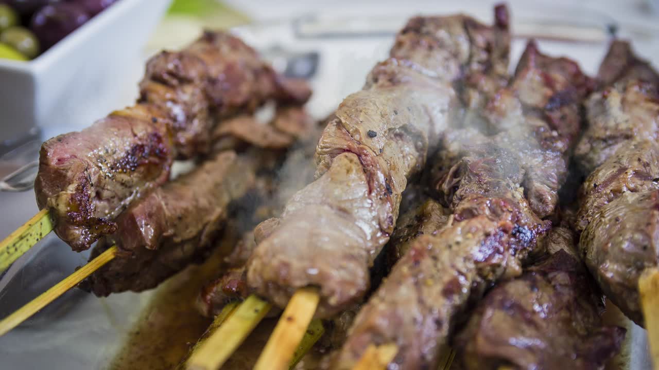 cinemagraph de fumaça emitida de uma pilha de shashlik grelhado quente com um espeto de madeira que está em uma placa branca
