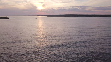 Aerial-shot-flying-out-over-the-Atlantic-Ocean-at-sunset-off-of-Kettle-Cove-Beach,-Maine