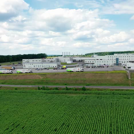 aerial view of modern storage warehouse with many trucks on parking lot. industrial zone on city suburb