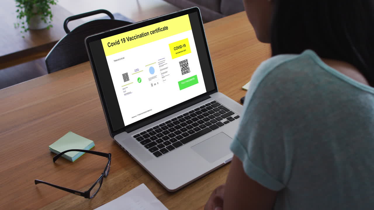 mujer trabajando en el escritorio, certificado de vacunación contra la covid con código qr en la pantalla del portátil