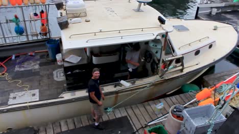 two lobstermen working on lobster boat on a sunday morning during an idle time.