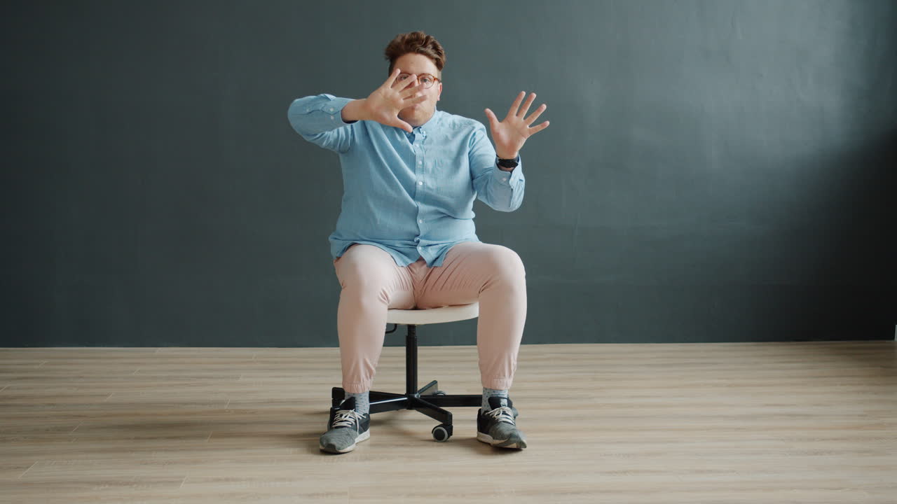 Man Sitting in Chair with Funny Expression