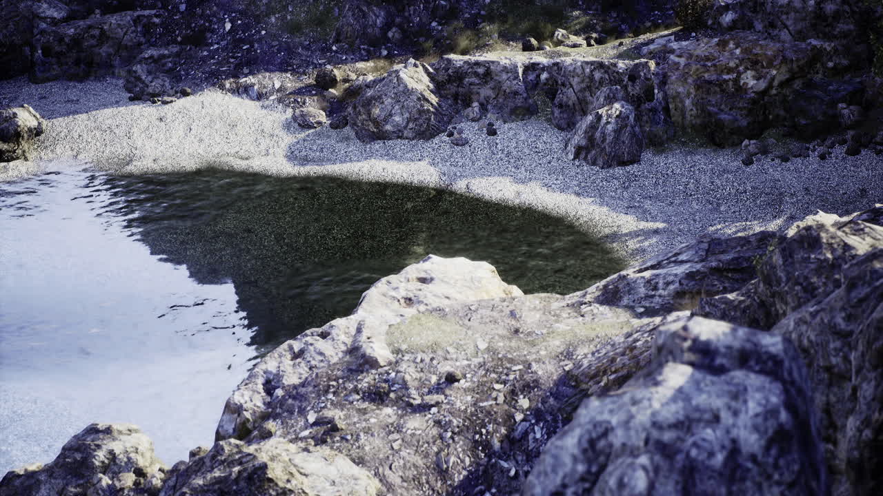 Fridfull stenig strandlinje vid en lugn sötvattenssjö under solnedgången