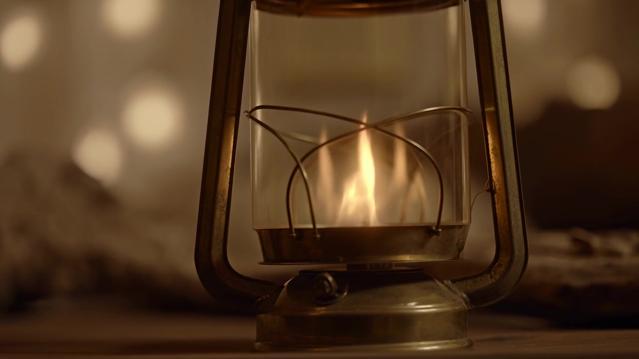 Scena in movimento ravvicinata mostra una lanterna a olio in metallo vintage con bagliore costante e leggero sfarfallio della fiamma su una superficie di legno opaca, circondata da un bokeh caldo e morbido, atmosfera interna rustica, con lanterna, fiamma.