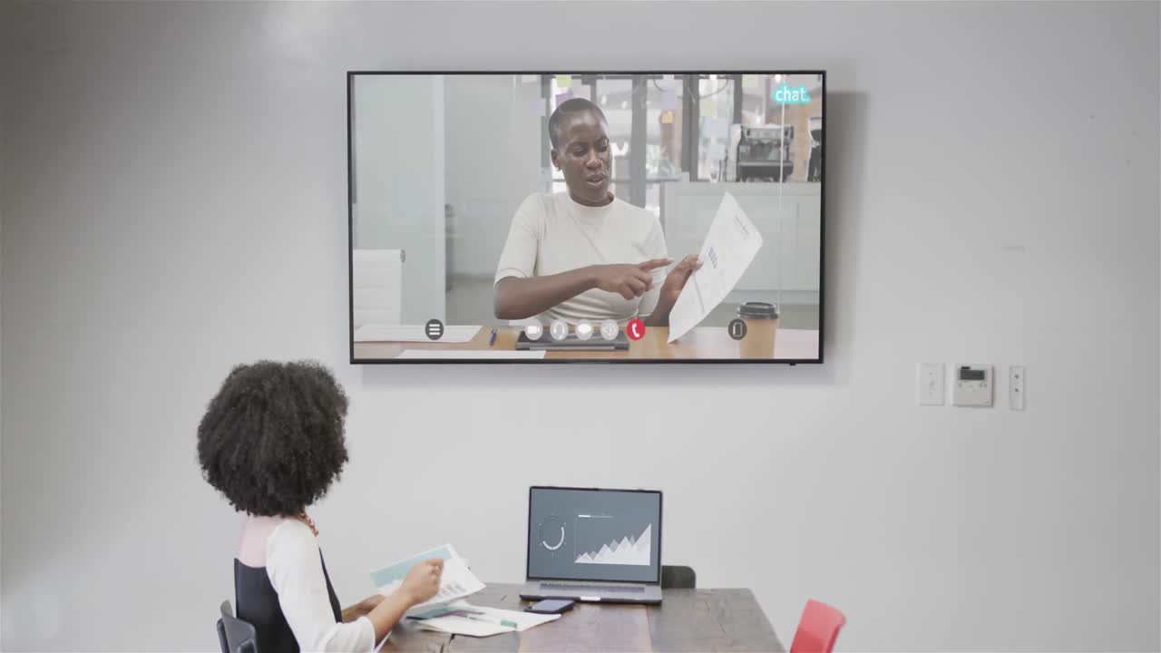 African american businesswoman on video call with african american female colleague on screen
