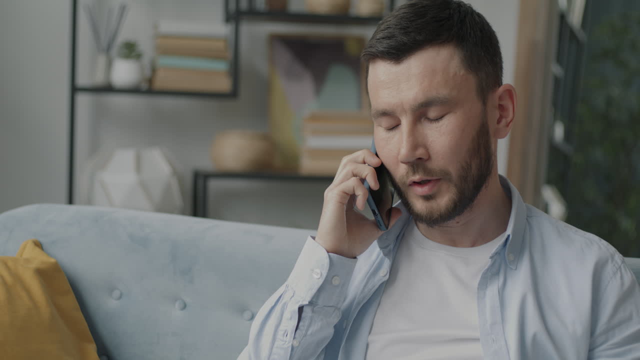 집에서 전화로 얘기하는 남자