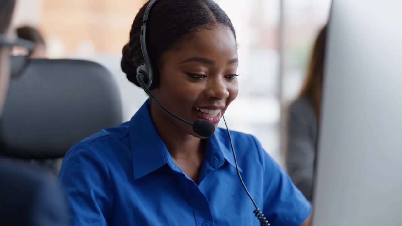 Focused Customer Service Agent in Professional Office Setting, Engaging with Clients and Providing Support Through Headset and Computer Technology