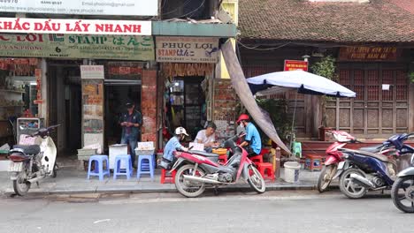 motorbikes passing by a traditional storefront