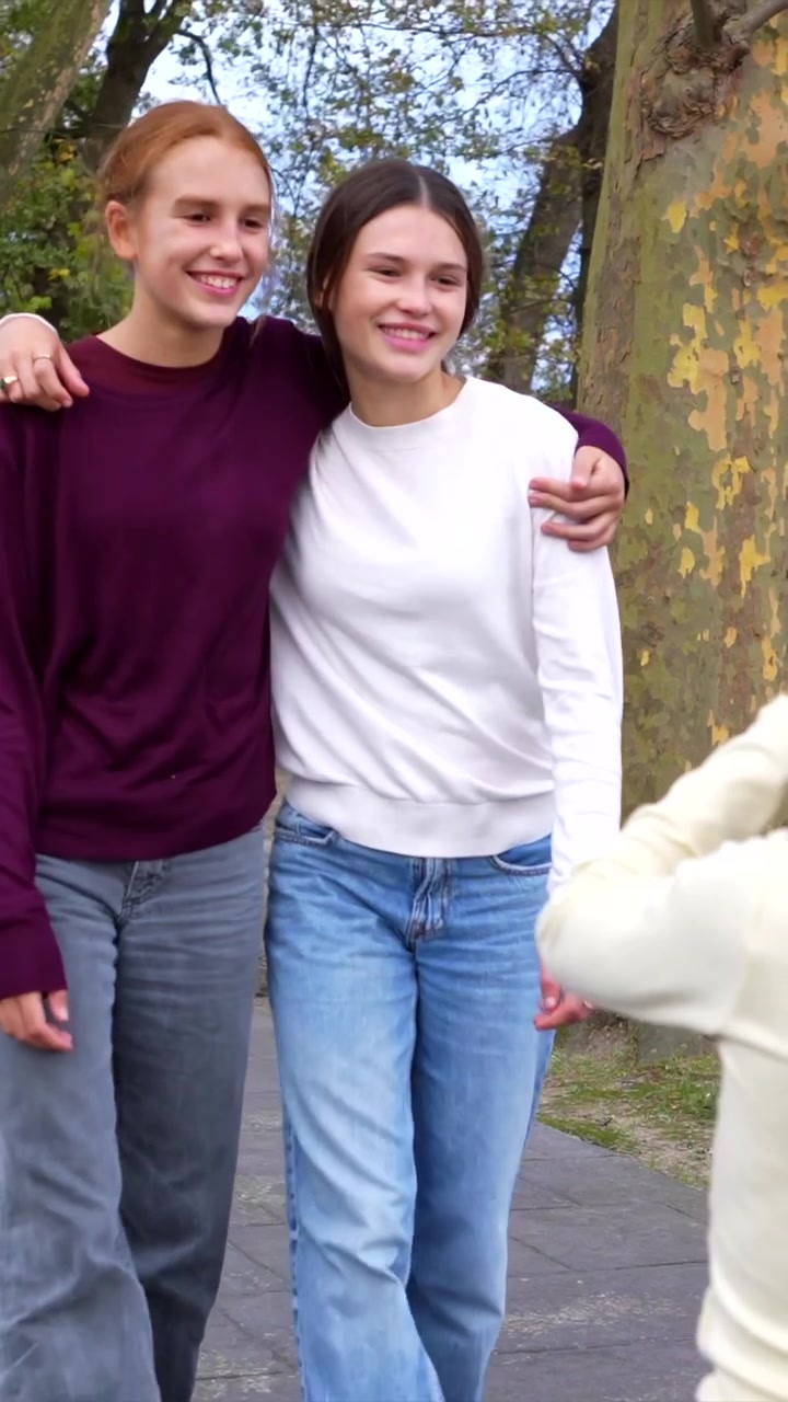 Giovane ragazza che scatta foto alle sue amiche in un parco.
