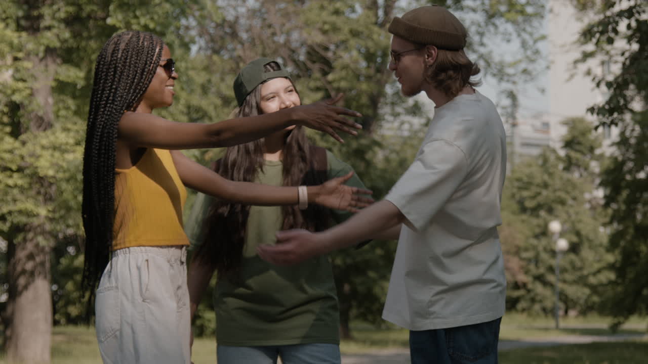 Diverse group of friends greeting each other in a park