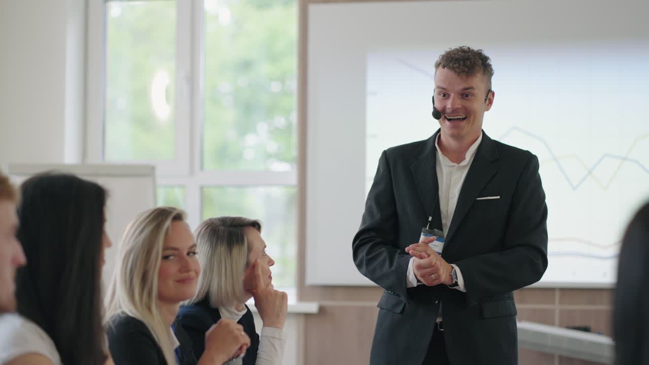 Energisk och positiv affärscoach talar med deltagare i utbildningsseminarium.